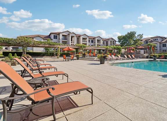 A pool area with sun loungers and a swimming pool.