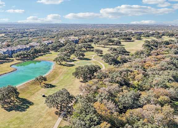 A beautiful aerial view of a park with a lake and trees at TalaVera Apartments, San Antonio, TX