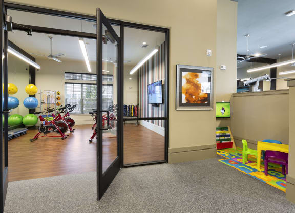 a gym with a variety of exercise equipment and glass doors at North Creek, Texas, 78634