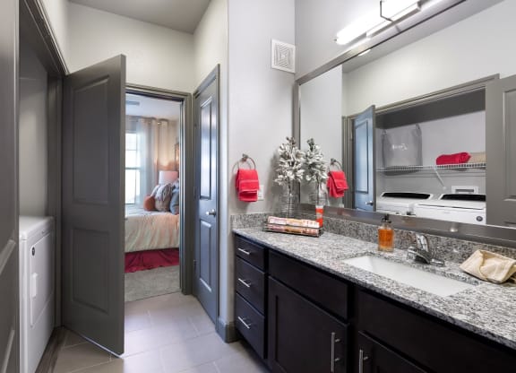 a bathroom with a sink and a mirror and a door to a bedroom at North Creek, Hutto, TX