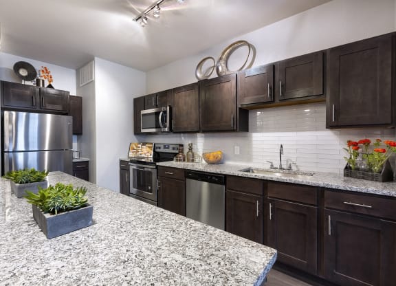 a kitchen with stainless steel appliances and granite counter tops at North Creek, Hutto