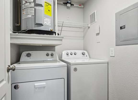 A white washing machine and dryer in a small laundry room.