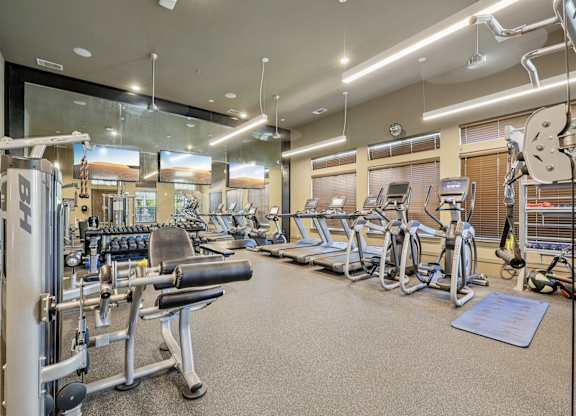 A well-equipped gym with a variety of machines and weightlifting equipment.at North Creek, Hutto, TX, 78634