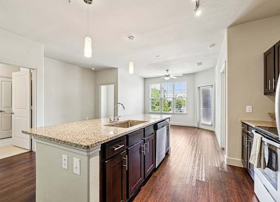 A kitchen with a granite countertop and dark wood cabinets at North Creek, Texas.