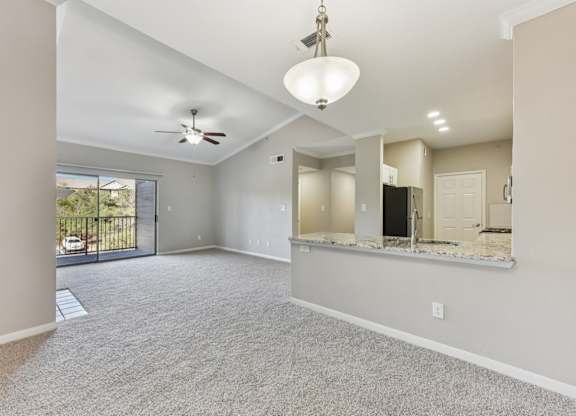 A spacious living room with a ceiling fan and sliding glass doors. at Sonterra Apartment Homes, Austin, 78726