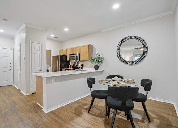 A kitchen with a dining table and chairs.