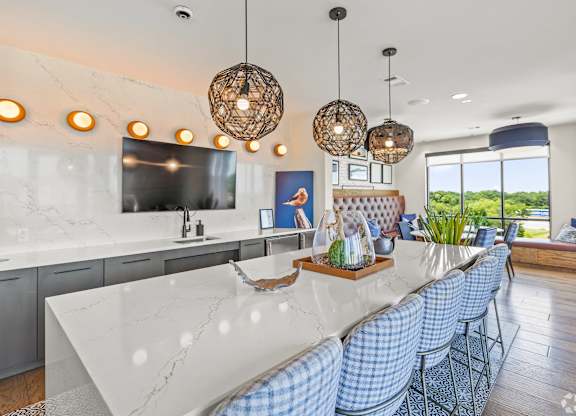 A modern kitchen with a marble countertop and blue chairs. at Aurora Watson Branch, Mansfield, 76063