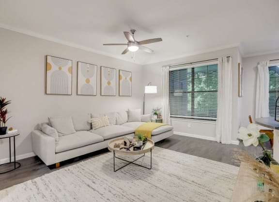 a living room with a white couch and a ceiling fan at The Vista on Brodie, Texas