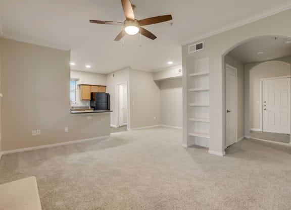 an empty living room with a ceiling fan and a kitchen at The Vista on Brodie, Austin, TX, 78745