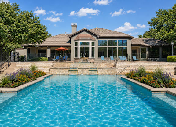 A large swimming pool in front of a house.