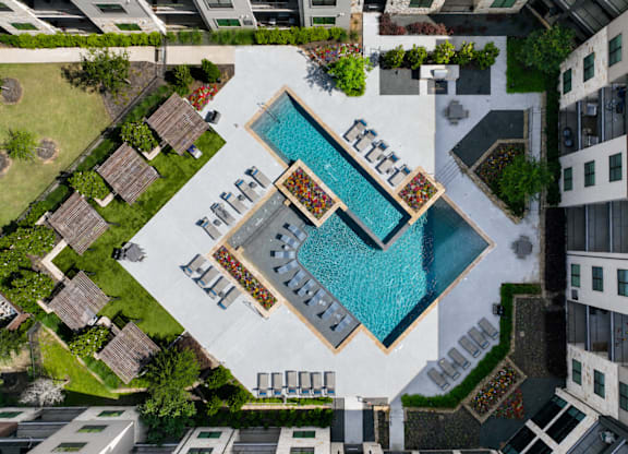 An aerial view of a pool surrounded by buildings.