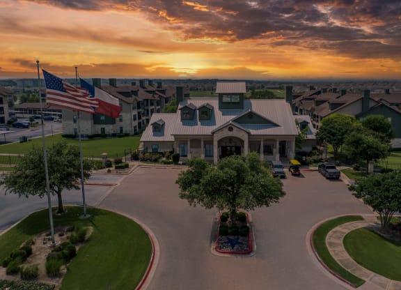 an aerial view of a building with an flag at sunset