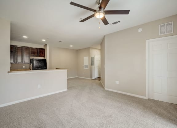 the living room and kitchen in a new home with a ceiling fan at Las Brisas Apartment Homes, Round Rock