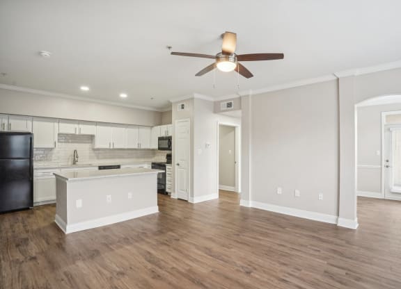 an empty living room and kitchen with a ceiling fan at The Verandah, Austin, TX, 78726