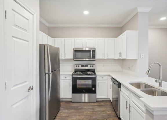 a white kitchen with stainless steel appliances and white cabinets  at The Verandah, Austin, 78726