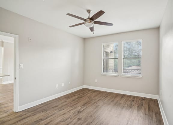 an empty living room with a ceiling fan and a window at The Verandah, Austin, TX, 78726