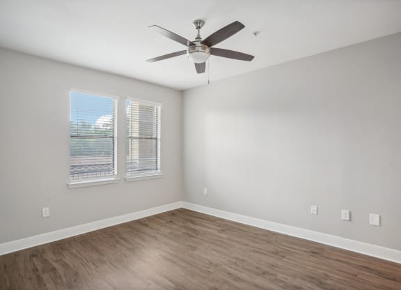 an empty living room with a ceiling fan and a window at The Verandah, Austin, TX