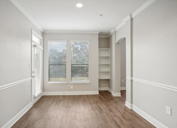 the living room of a new home with white walls and wood flooring  at The Verandah, Austin, TX, 78726