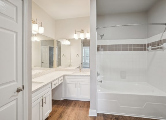 a bathroom with a tub and a sink and a mirror  at The Verandah, Austin, TX, 78726