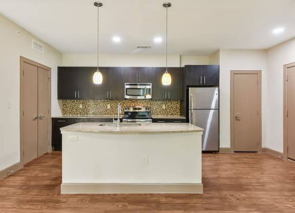 a kitchen with a large island and a stainless steel refrigerator at Lakeline East Apartments, Cedar Park, 78613