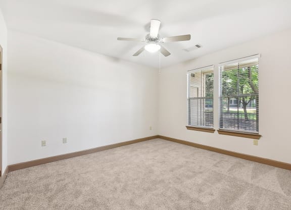 an empty living room with a ceiling fan and a window at Lakeline East Apartments, Texas