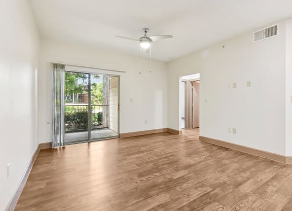 an empty living room with a sliding glass door to a patio at Lakeline East Apartments, Cedar Park
