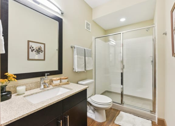 a bathroom with a shower toilet sink and mirror at Lakeline East Apartments, Cedar Park, 78613