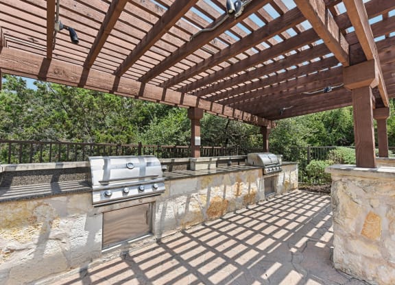 a patio with a barbecue grill and a pergola at Lakeline East Apartments, Cedar Park, 78613