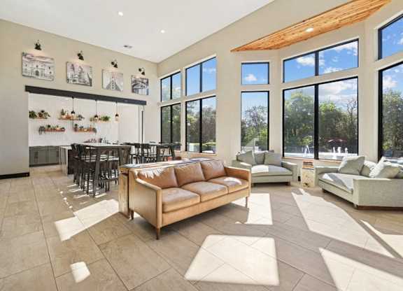 a living room with a couch and a table in front of a large window