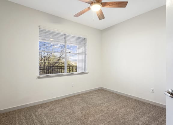 an empty room with a large window and a ceiling fan at The Legends at Eagle Mountain Lake, Fort Worth, TX, 76179
