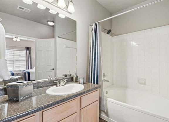 a bathroom with a sink and a tub and a mirror