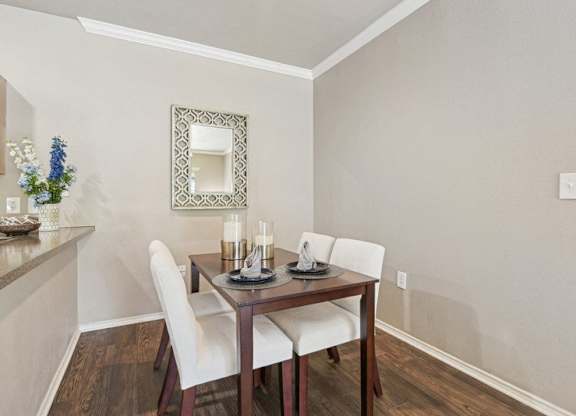 a dining room with a table and chairs and a mirror