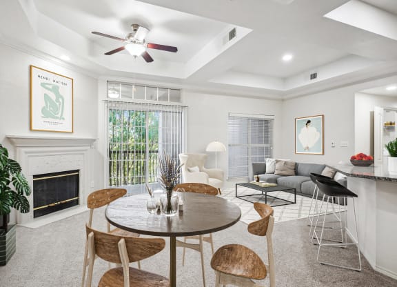 a living room with a table and chairs and a fireplace at La Ventura Apartments, Plano, 75093