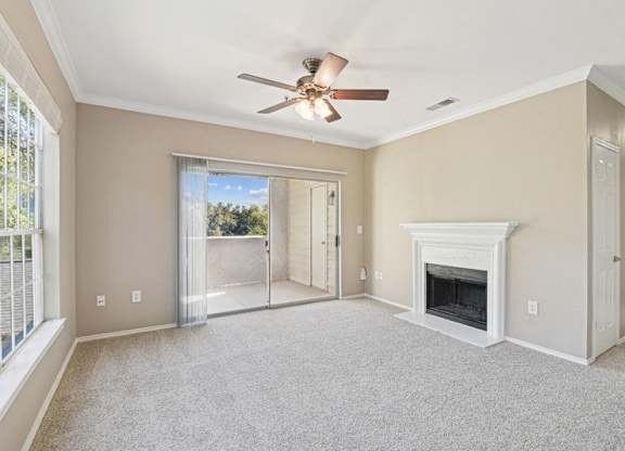 an empty living room with a fireplace and a ceiling fan
