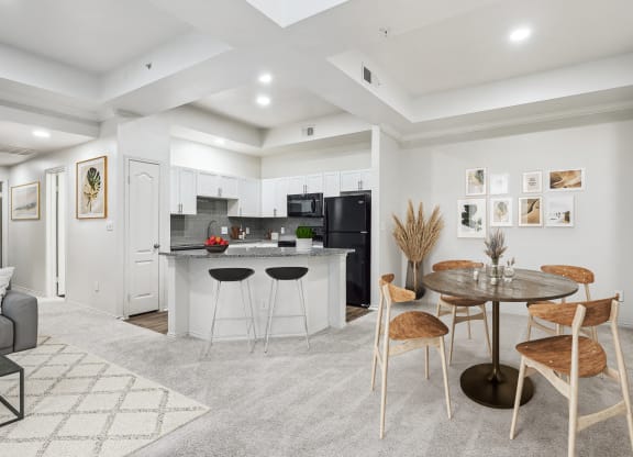 a living room with a kitchen and a dining table at La Ventura Apartments, Plano
