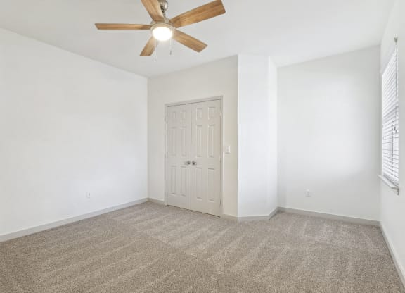 an empty living room with white walls and a ceiling fan at The Legends at Eagle Mountain Lake, Texas, 76179