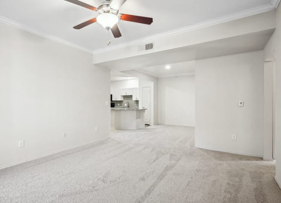 an empty living room with white walls and a ceiling fan at La Ventura Apartments, Plano, TX, 75093