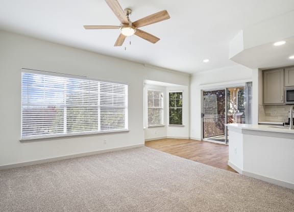 an empty living room with a ceiling fan and a kitchen at The Legends at Eagle Mountain Lake, Fort Worth, Texas