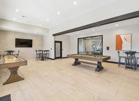 the game room with two pool tables and a television