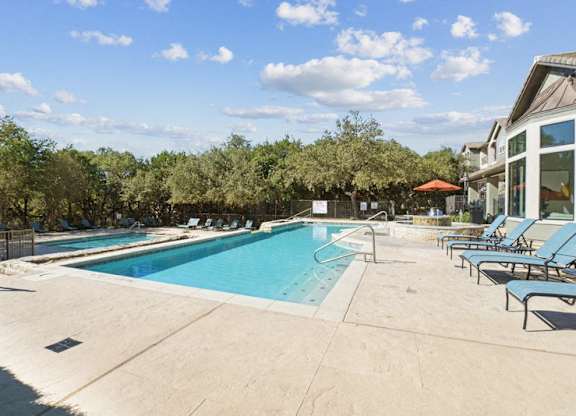 a swimming pool in a resort with chairs and a blue sky stock images