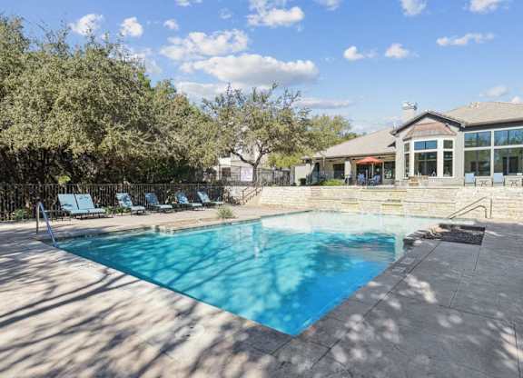 a swimming pool with a house in the background