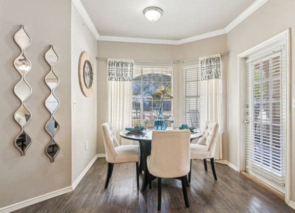 a dining room with a table and chairs and a window