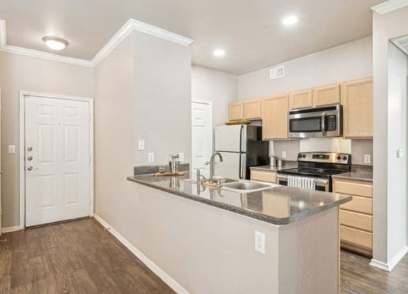 an empty kitchen with a counter top and a sink