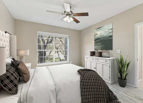 a bedroom with a large bed and a ceiling fan