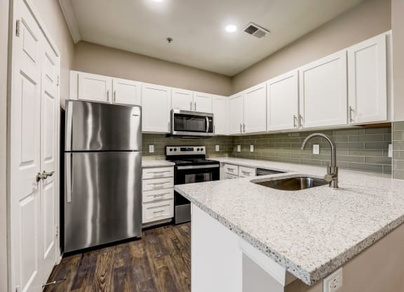 a kitchen with white cabinets and stainless steel appliances at Ventana Oaks Apartments, Austin, 78717