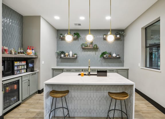 a kitchen with a large island and three stools at Ventana Oaks Apartments, Texas