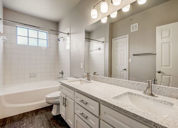 a bathroom with a sink and a toilet and a tub at Ventana Oaks Apartments, Austin