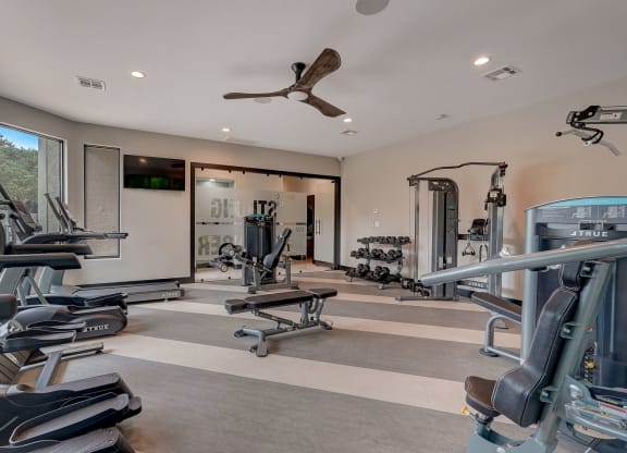 a gym with weights and cardio equipment in a home for sale