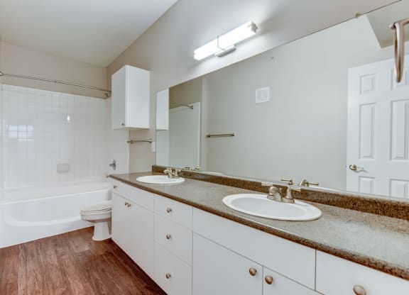 the preserve at ballantyne commons apartment bathroom with two sinks and a bath tub