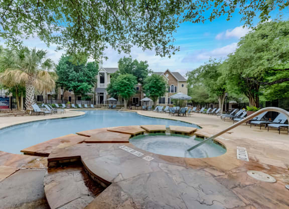 a swimming pool with chairs and trees and a resort style pool
